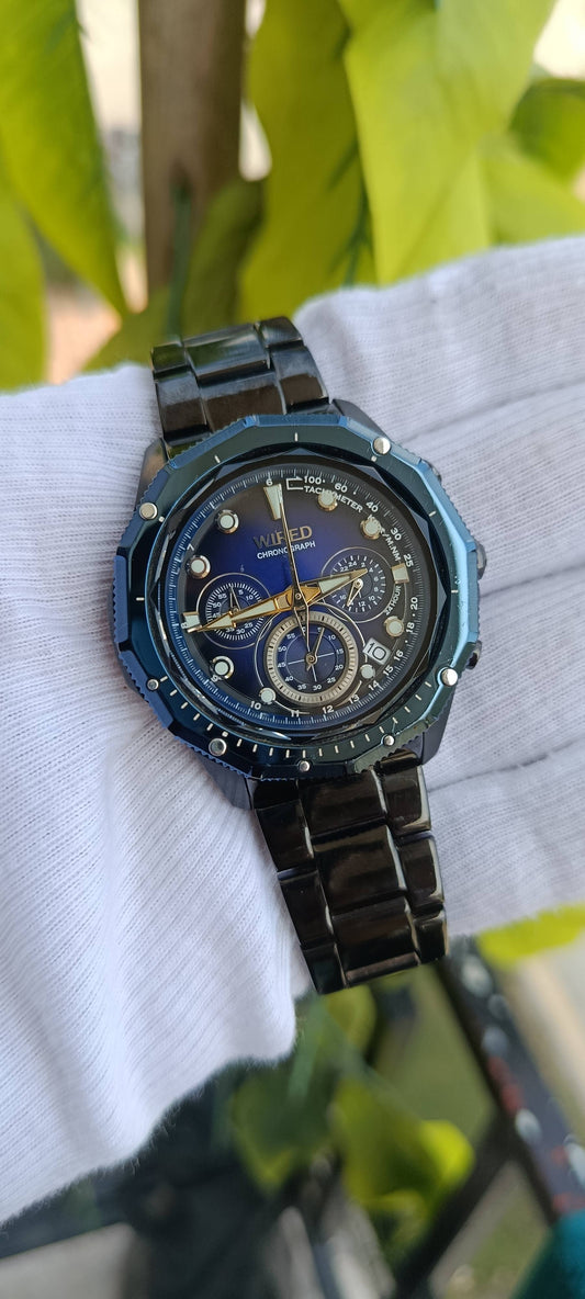 Seiko Wired Chronograph Watch | Blue Sunburst Multi-Dial Face | Tachymeter Bezel | 24-Hour Subdial | Date Display | Gold-Tone Hands | Black IP Stainless Steel Case & Bracelet | Movement 8T63